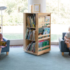 Families seated in the library porch reading children's books