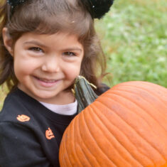 child with pumpkin